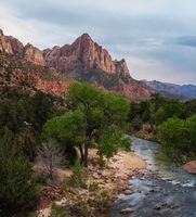 The Watchman Over the Virgin River — Zion National Park, Utah The Watchman stands proudly above the flowing Virgin River in Zion National Park, glowing with the warm hues of the surrounding red rock cliffs. Soft evening...