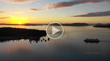 Northwest Aerial Photography Anacortes Ferry Dock Sunset Beautiful 4K drone footage of a Washington State ferry approaching the Anacortes ferry dock at sunset. The golden light of evening reflects across the calm...