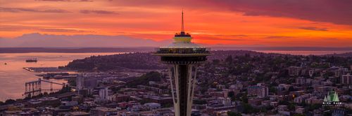 Aerial Seattle Sunset Space Needle Panorama Aerial view of the Seattle Space Needle at sunset with the Olympic Mountains and Puget Sound glowing in the background. Brilliant orange and magenta hues light...