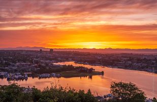 Lake Union Sunrise from Queen Anne Brilliant orange sunrise over Lake Union seen from Queen Anne Hill in Seattle, with the University District and Gas Works Park reflecting in the calm morning...