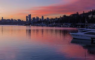 Lake Union Sunrise Seattle skyline reflected on calm Lake Union in the soft light of morning, with the Space Needle and downtown buildings glowing under a pastel sunrise sky.