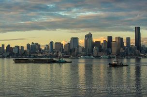 Elliott Bay Working Harbor Seattle Skyline Tugboats and barges move across Elliott Bay with the Seattle skyline in the background under soft evening light.
