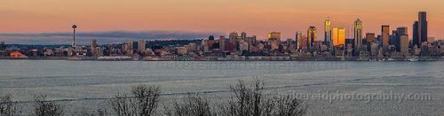 Golden Glow Seattle Panoramic view of the Seattle skyline from Hamilton Viewpoint in West Seattle with golden evening light reflecting off downtown skyscrapers above Elliott Bay.