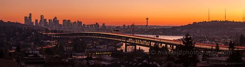 Seattle Interstate 5 Bridge Wide Sunset UW Panorama A glowing Seattle sunset paints the sky orange and gold as streaks of headlights and taillights trace graceful lines across the Interstate 5 bridge. The Space...