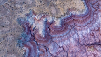 Aerial Patterns and Colors of the Bentonite Hills, Utah An extraordinary aerial view of the Bentonite Hills near Capitol Reef National Park, Utah, where swirling layers of clay and volcanic ash reveal surreal tones...