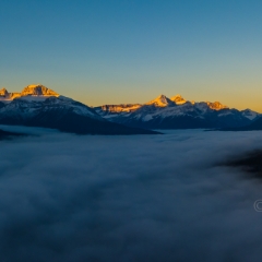 Over the Canadian Rockies Peaks Above the Clouds Sunrise Pano.jpg