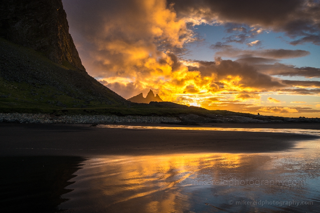Iceland Stokksnes Vestrahorn Brunnhorn Sunrise Reflection A brilliant sunrise ignites the sky behind the jagged peaks of Vestrahorn, mirrored in the wet sands of Stokksnes Beach. The glowing light and dramatic clouds create a scene of elemental power and beauty — a true Icelandic moment of dawn. Fine-art landscape photograph by Mike Reid capturing the raw intensity and reflection of morning light at Vestrahorn.