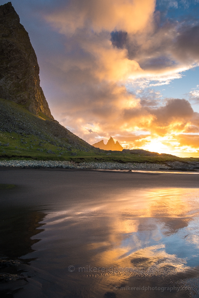 Iceland Stokksnes Vestrahorn Sunrise Reflection Sand A brilliant sunrise ignites the sky behind the jagged peaks of Vestrahorn, mirrored in the wet sands of Stokksnes Beach.
