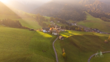 Aerial Italian Dolomites Val di Funes Sunlit Church.jpg default