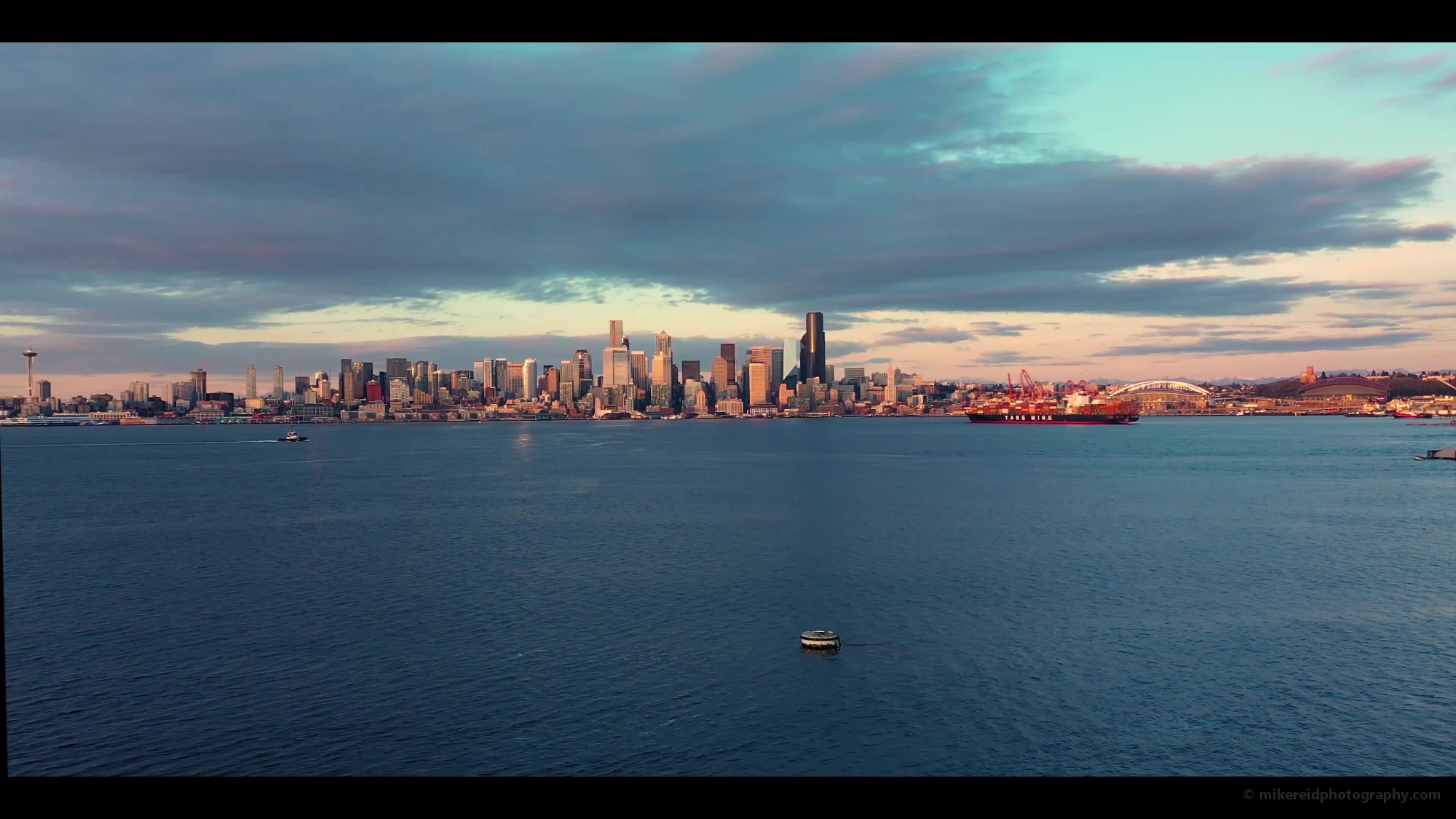 Aerial View of Elliott Bay with Tugs and Ferries and Downtown Seattle Drone Video.