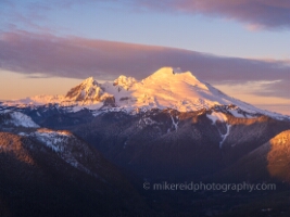 Over the North Cascades Mount Baker Dusk Warmth Bathed in soft alpenglow, Mount Baker and its striking neighbor Colfax Peak glow under the golden hues of sunrise in this serene alpine composition. Captured in...