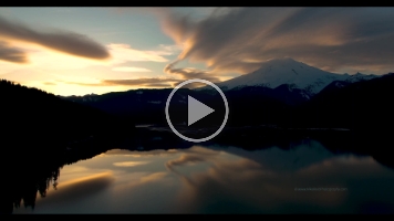 Mount Baker Sunset Cloudscape Video.mp4 Stunning 4K aerial footage of Mount Baker glowing in golden light above the calm waters of Baker Lake. Clouds drift through the North Cascades as the setting...