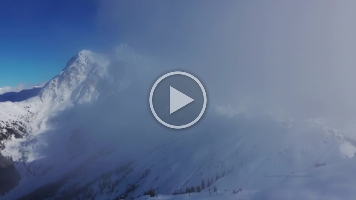 Mount Shuksan and Mount Baker Ski Area Drone Video.mp4 Moody 4K aerial footage of Mount Shuksan wrapped in drifting winter clouds above the snow-covered slopes of the Mount Baker Ski Area. Soft light filters through...