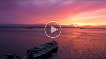 Over Edmonds Ferry Docking at Sunset Drone Video.mp4 Beautiful 4K aerial drone footage of the Edmonds ferry gliding toward the dock at sunset across Puget Sound. Golden light reflects off the calm evening water as...