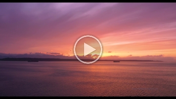 Over Puget Sound Container Ships Sailing at Sunset Drone Video.mp4 Beautiful 4K aerial footage of container ships crossing Puget Sound at sunset, captured over the glowing waters of the Salish Sea. The golden evening light...