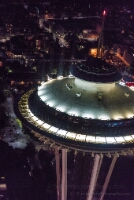 Aerial Night Space Needle Aerial night view of Seattle’s Space Needle illuminated against the city lights below. The glowing observation deck and soft streetlights create a striking...