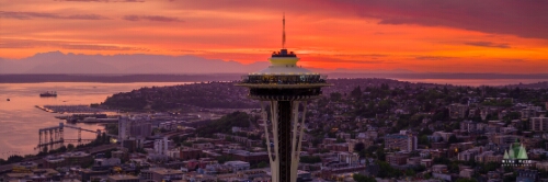 Aerial Seattle Sunset Space Needle Panorama Aerial view of the Seattle Space Needle at sunset with the Olympic Mountains and Puget Sound glowing in the background. Brilliant orange and magenta hues light...