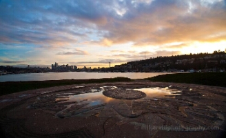 Gasworks Sunset Hill Pool Reflection View from atop Sunset Hill at Gas Works Park overlooking Lake Union toward the Seattle skyline and Space Needle at sunset, with golden light reflecting in...