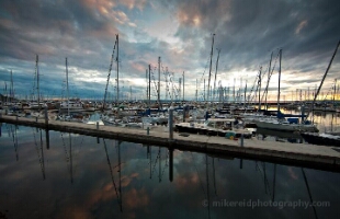 Shilshole Marina Reflection Sunset Clouds Canon 14mm Wide-angle view of Shilshole Bay Marina in Seattle captured at 14mm, showing rows of sailboats and dramatic evening clouds reflected in still water.