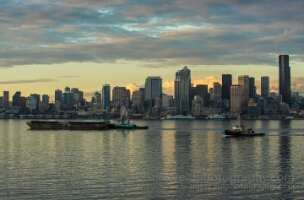 Elliott Bay Working Harbor Seattle Skyline Tugboats and barges move across Elliott Bay with the Seattle skyline in the background under soft evening light.
