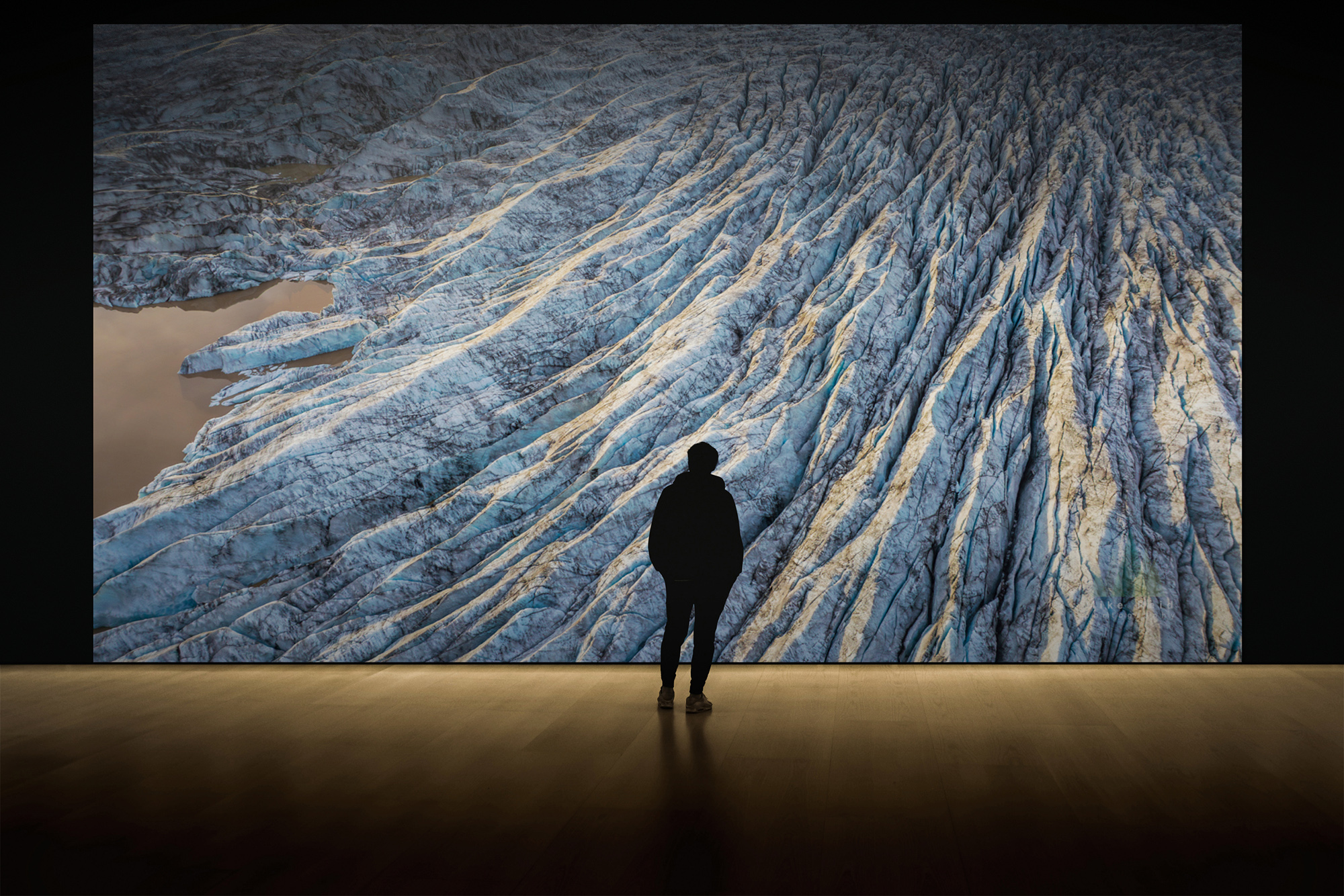 Monumental abstract glacial photograph with silhouetted viewer for scale