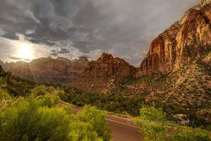 Sunset Light Over Zion Canyon — Zion National Park, Utah Soft golden light spills across the sandstone cliffs of Zion National Park, illuminating the rugged canyon walls and lush valley below. The winding park road...