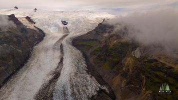 Glacial Road, Iceland – Aerial View of Flowing Ice and Mountain Valleys This dramatic aerial photograph captures a glacier carving its path through Iceland’s rugged mountain landscape, creating what appears to be a natural “road” of...
