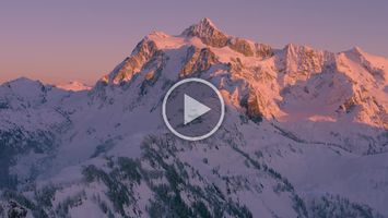 Mount Shuksan and Artists Point Snowscape Alpenglow Video Magnificent 4K aerial footage of Mount Shuksan glowing in brilliant alpenglow at sunset above the snow-covered peaks of the North Cascades. The fading light...