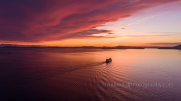 Northwest Aerial Photography San Juan Islands Ferry Peaceful Tranquility.jpg A peaceful aerial view of a Washington State ferry gliding across Puget Sound toward the San Juan Islands under a vivid red and orange sunset sky. The evening...
