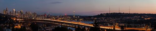 Wide Seattle Cityscape and Interstate 5 Bridge at Night A glowing Seattle twilight paints the sky hues of blue as streaks of headlights and taillights trace graceful lines across the Interstate 5 bridge. The Space...