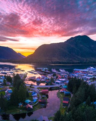 Petersburg Alaska Sunset Over Sons of Norway Hall and Hammer Slough A breathtaking aerial view of Petersburg, Alaska, at sunset, with the warm glow of evening light reflecting across Hammer Slough and the historic Sons of Norway...