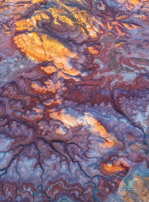 Sunset Light Over the Bentonite Hills, Utah — Aerial Desert Colors An aerial photograph of the Bentonite Hills near Capitol Reef National Park, Utah, glowing under the last rays of sunset light. The swirling layers of bentonite...