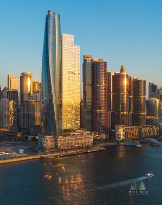 Aerial View of Crown Sydney and Barangaroo at Sunset – Sydney Harbour Skyline An aerial photograph capturing the sleek silhouette of Crown Sydney rising above Barangaroo as the warm sunset light glows across Sydney Harbour. The golden...