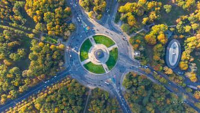 Victory Column from Above in Autumn Berlin A straight-down aerial view over the Großer Stern in Berlin’s Tiergarten, centered on the Victory Column and the circular traffic pattern surrounding it. Autumn...