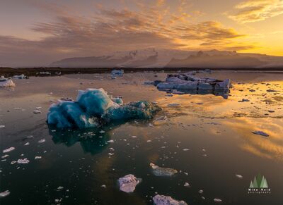 Jökulsárlón Iceberg Sunset – Aerial View over Iceland’s Glacial Lagoon This mesmerizing aerial photograph captures the glowing beauty of Jökulsárlón glacial lagoon at sunset, as floating icebergs drift across calm, reflective...