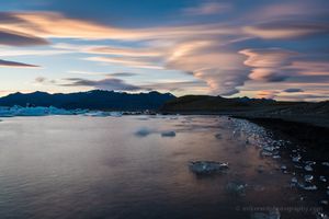 Lenticular Clouds and Beach Ice – Jökulsárlón Sunset, Iceland At sunset along Iceland’s Jökulsárlón Glacier Lagoon, lenticular clouds sweep across the sky in layers of soft color above ice fragments washed ashore. The...