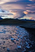Iceland Jokulsarlon Lenticular Clouds and Beach Jewels A dramatic sunset unfolds over Iceland’s Jökulsárlón Glacier Lagoon as lenticular clouds swirl above a shoreline strewn with crystal-blue ice. Each fragment...