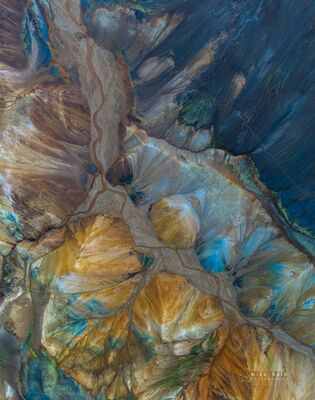 Blue and Gold Volcanic Patterns of Landmannalaugar An aerial view of the richly colored volcanic terrain of Landmannalaugar in Iceland’s Highlands. Blue-gray mineral slopes, golden rhyolite ridges, and winding...
