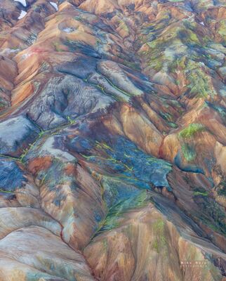 Rhyolite Color Patterns in Landmannalaugar An aerial panorama of the mineral-rich rhyolite mountains of Landmannalaugar in Iceland’s Highlands, where blue-gray, rust, gold, and green tones fold across...