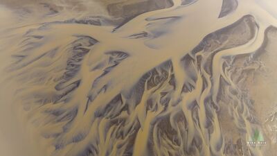 Aerial Abstract of Icelandic Glacial Rivers – Nature’s Flowing Canvas This stunning aerial photograph showcases the intricate patterns of Iceland’s glacial river systems, where meltwater streams branch and weave across volcanic...