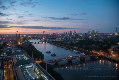 London Skyline and River Thames at Blue Hour An elevated blue-hour view over the River Thames in London, with the Houses of Parliament and Big Ben at left, the London Eye along the river, and the city...