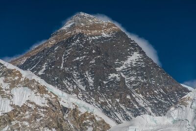 Mount Everest Summit and Windblown Clouds Above Nuptse A close-up view of Mount Everest's towering summit rising above the snow-covered ridges of Nuptse in Nepal's Khumbu region. Strong winds sweep clouds from the...