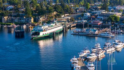 Friday Harbor Ferry Terminal and Marina from Above An aerial view of Friday Harbor on San Juan Island with a Washington State Ferry at the terminal and rows of boats filling the marina below. The image looks...