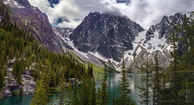 Lake Colchuck Panorama View A wide view of Lake Colchuck in Washington’s Alpine Lakes Wilderness, with turquoise water framed by evergreen forest and the rugged peaks of the Stuart Range....