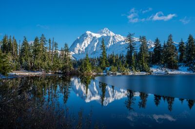 First Ice on Picture Lake, Mount Shuksan Early ice begins to form across Picture Lake beneath a fresh snow-covered Mount Shuksan. Clear autumn light, still water, and the mountain’s reflection create a...