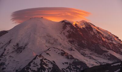 Mount Rainier Sunset Lenticular Cloud from Sunrise Side A striking lenticular cloud glows with warm sunset light above the summit of Mount Rainier, seen from the Sunrise side of Mount Rainier National Park in...