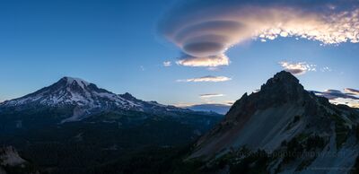 Lenticular Cloud Over Mount Rainier from Pinnacle Saddle at Dawn A massive lenticular cloud formation hovers above Mount Rainier and Pinnacle Peak in this breathtaking dawn view from Pinnacle Saddle. Soft morning light...