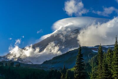 Halo Lenticular Cloud Over Mount Rainier from the Skyline Trail A luminous lenticular cloud drifts across the summit of Mount Rainier, forming a glowing halo in the crisp alpine air above the Skyline Trail. Sunlight breaks...