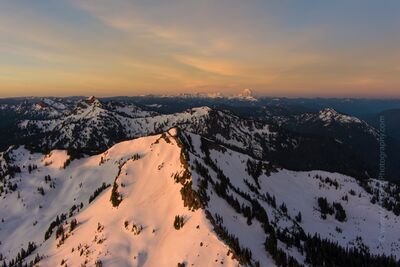 Naches Peak Sunrise with Mount Adams in the Distance – Pacific Northwest Aerial Landscape A breathtaking sunrise view over Naches Peak in Washington’s Cascades, captured in soft pastel light as dawn illuminates the snow-covered ridgeline. Mount Adams...