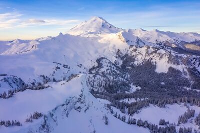 Northwest Aerial Photography Mount Baker Snowscape Aerial view of Mount Baker and Table Mountain bathed in the soft glow of morning light. The snow-covered ridges roll gently into the distance beneath a calm...
